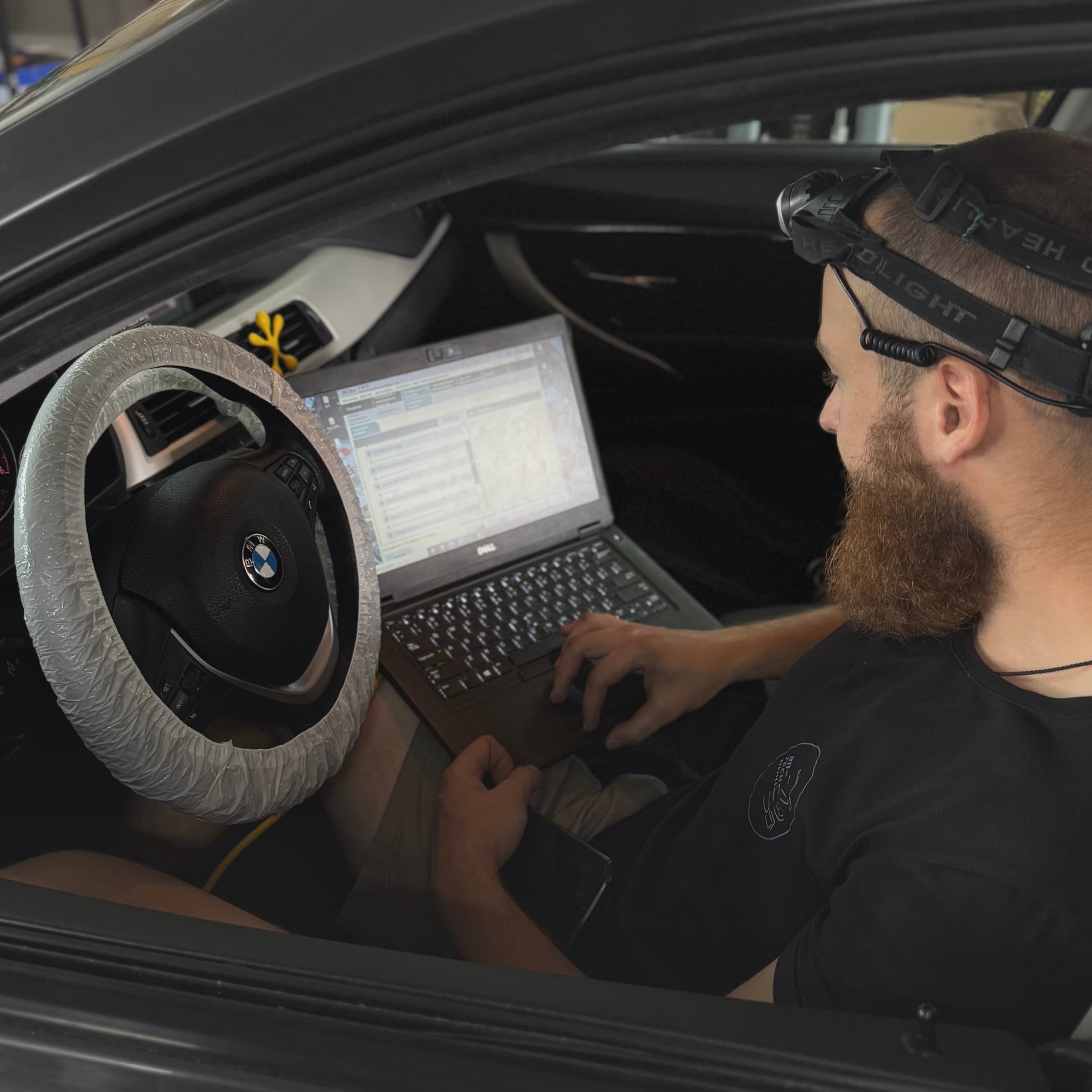 Майстер M-Tech з ноутбуком проводить комп'ютерну діагностику BMW